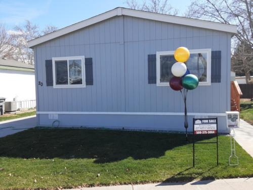 A mobile home with balloons in front of it.