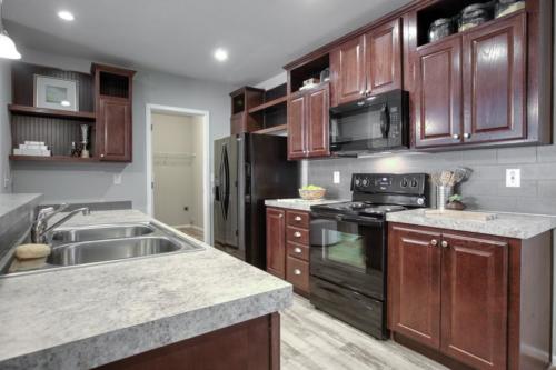 A kitchen with brown cabinets and granite counter tops.